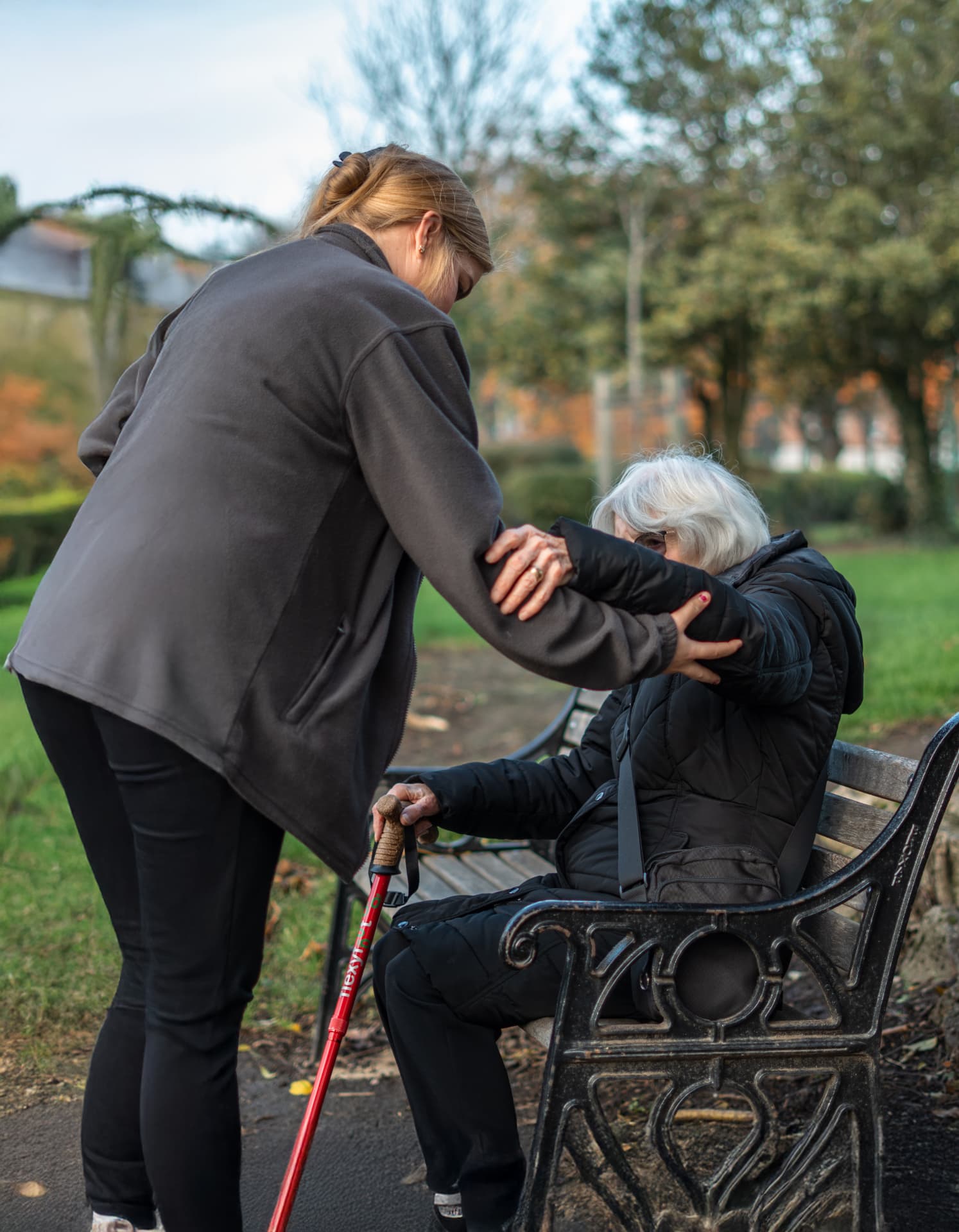 A Walfinch Newcastle carer helping an older client up from a park bench
