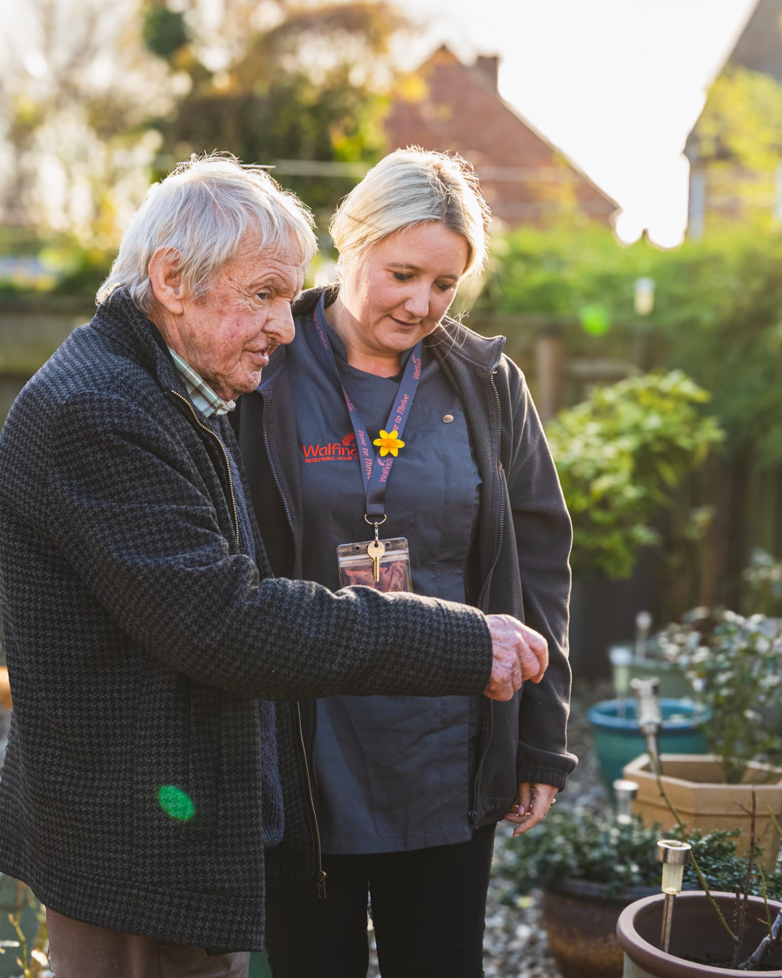 A Walfinch Newcastle carer supporting an older client to walk in his garden